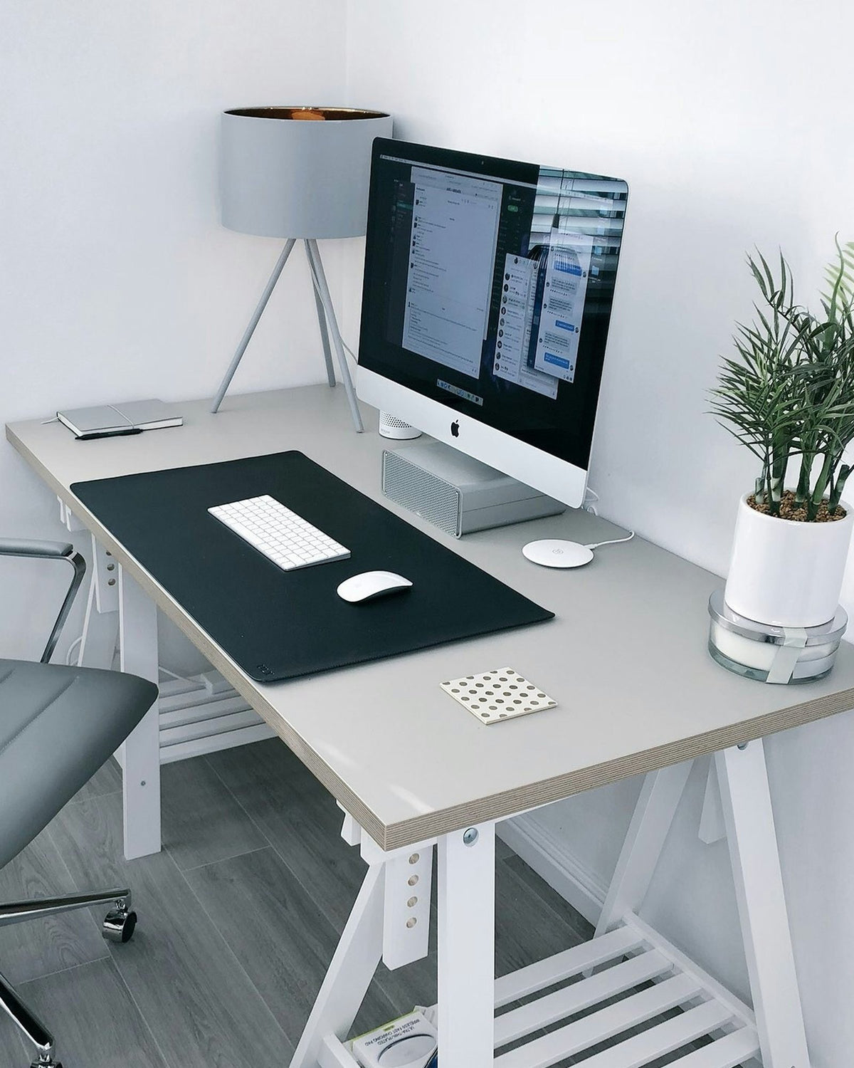 Home office corner with a grey office chair at a trestle desk