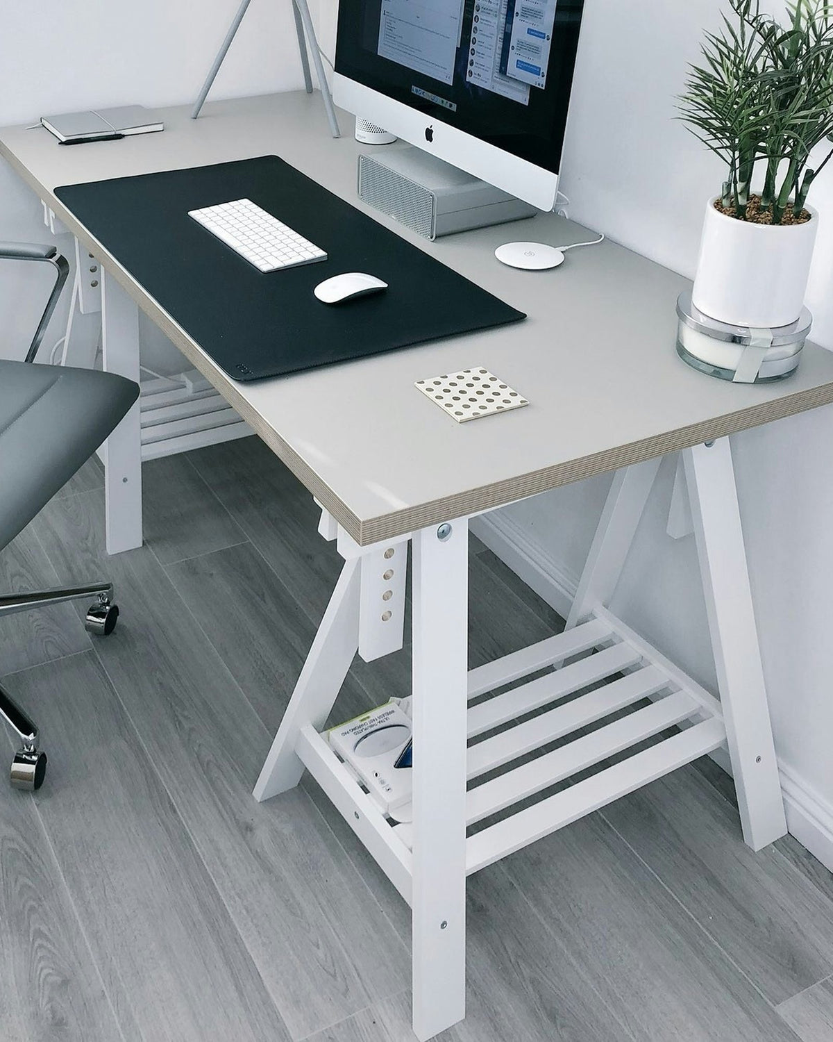 Home office corner with a grey office chair at a trestle desk