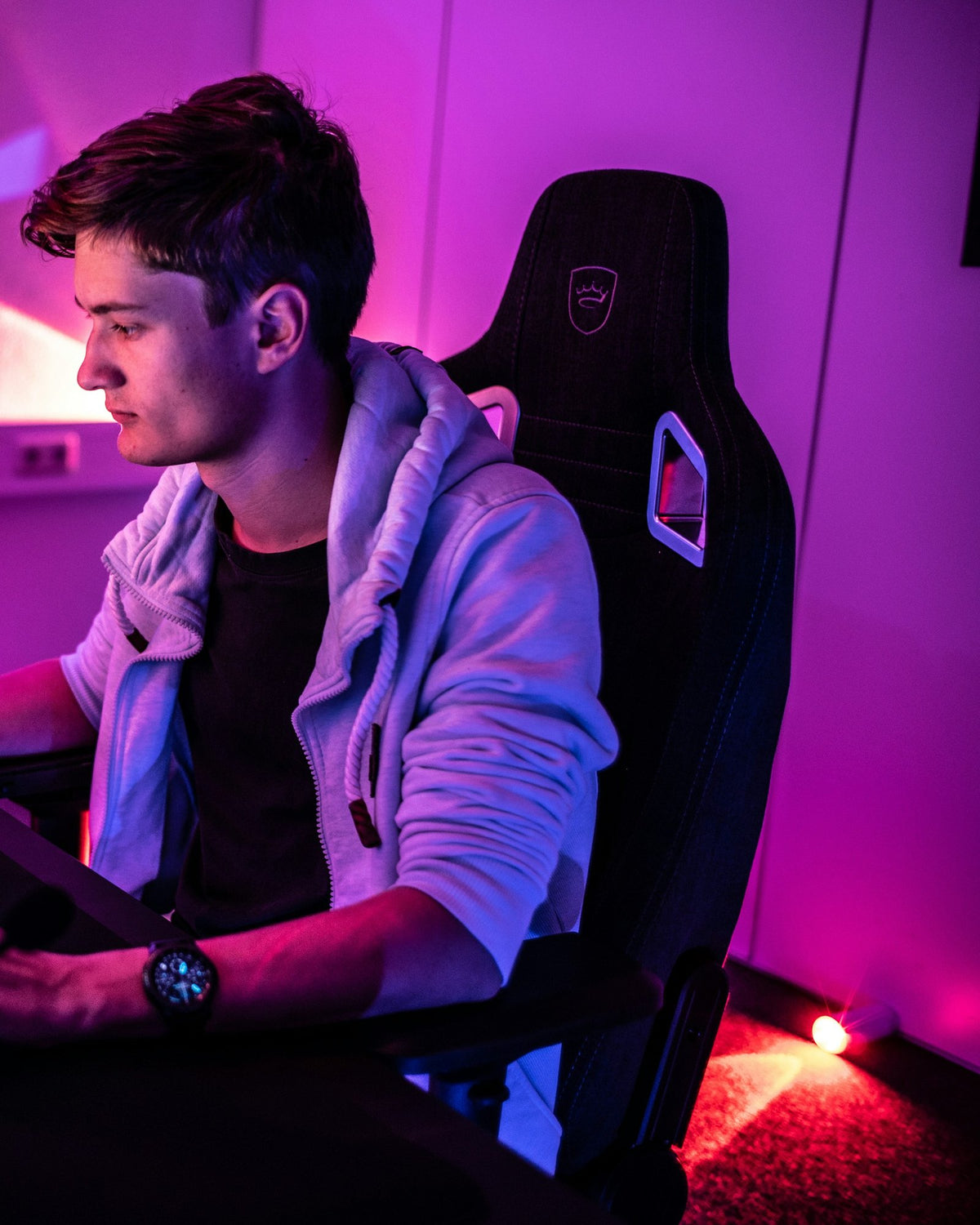 Person playing at a PC, seated in a black gaming chair