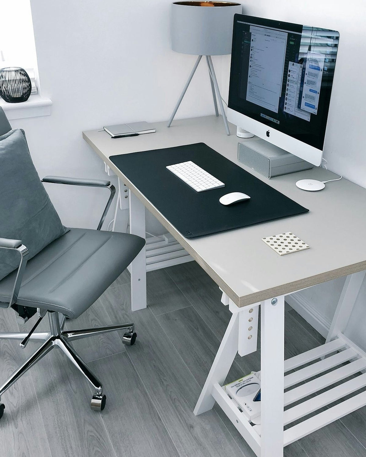 Home office corner with a grey office chair at a trestle desk