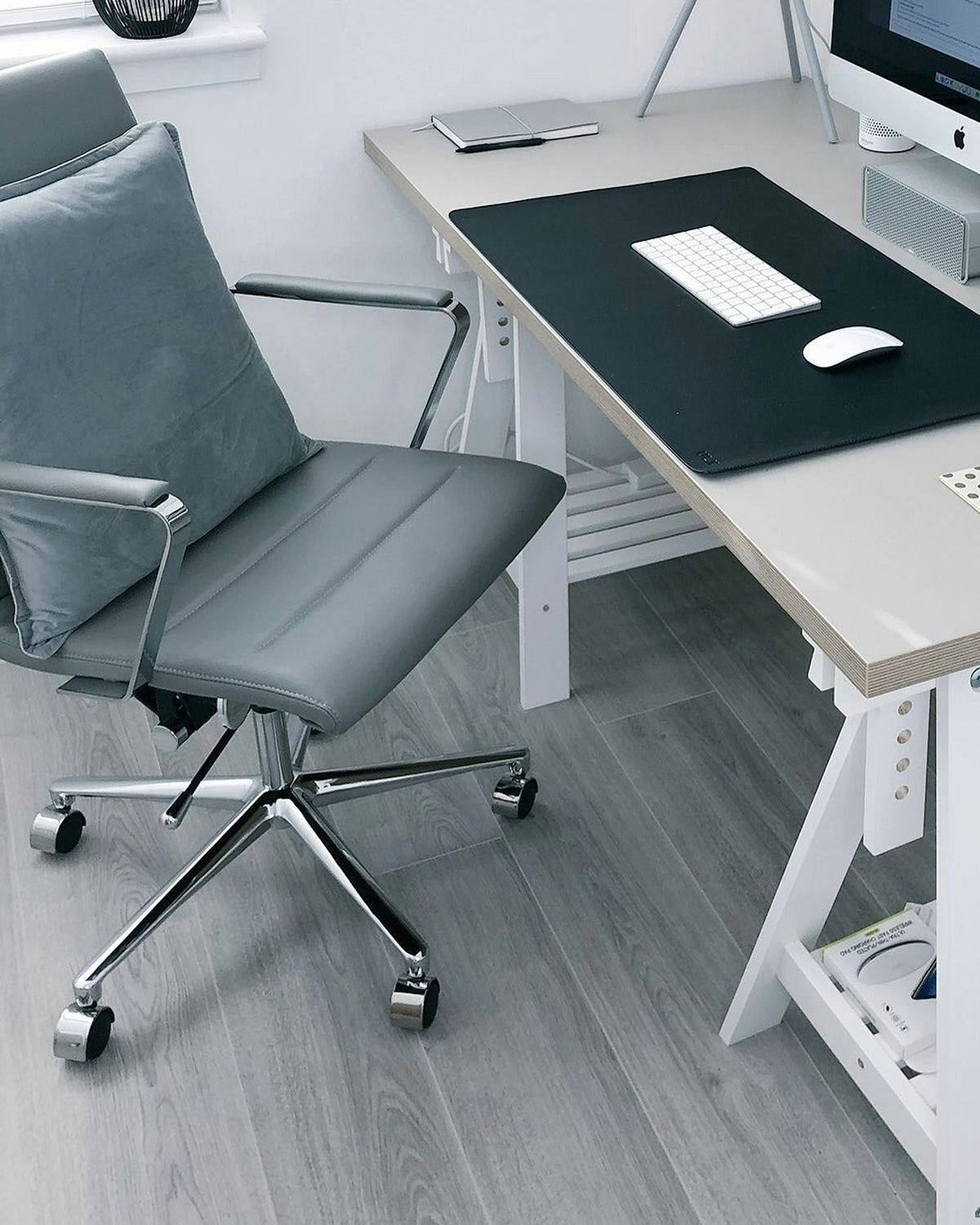 Home office corner with a grey office chair at a trestle desk