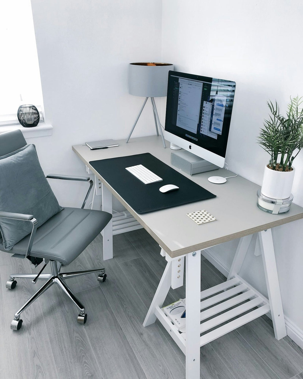 Home office corner with a grey office chair at a trestle desk